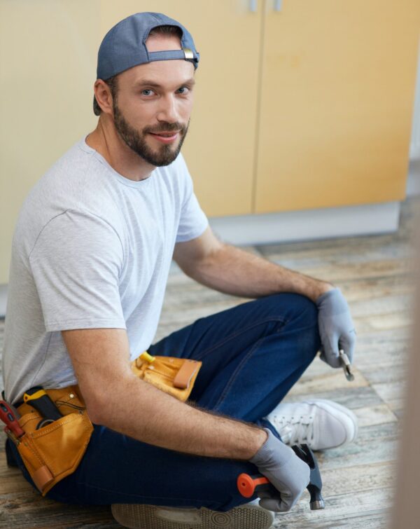 full-length-shot-of-young-repairman-looking-at-camera-holding-plumbing-tools-in-his-hands